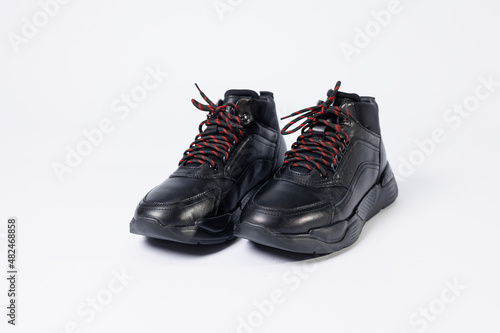 Leather black short men's autumn sneakers on a white background. Sneakers winter collection 2022.