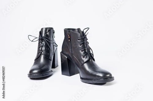 Women's boots with black genuine leather on heels isolated on a white background. photo from the side, diagonally and foreshortened from behind. Women's shoe collection 2022