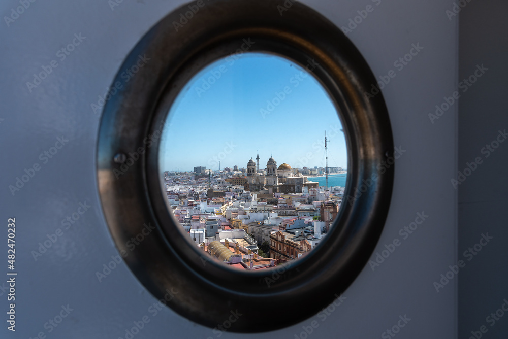 View of the old city rooftops and Cathedral de la Santa Cruz through a window in tower Tavira in Cadiz, Andalusia, Spain