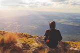 young woman on top of a mountain appreciating the landscape on a afternoon relaxed with her backpack and enjoying