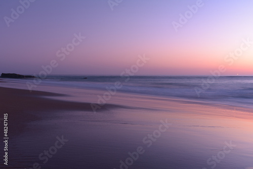 Sunset on the beach of Cape Trafalgar with the lighthouse in the background, Canos de Meca, Cadiz, Andalusia, Spain photo