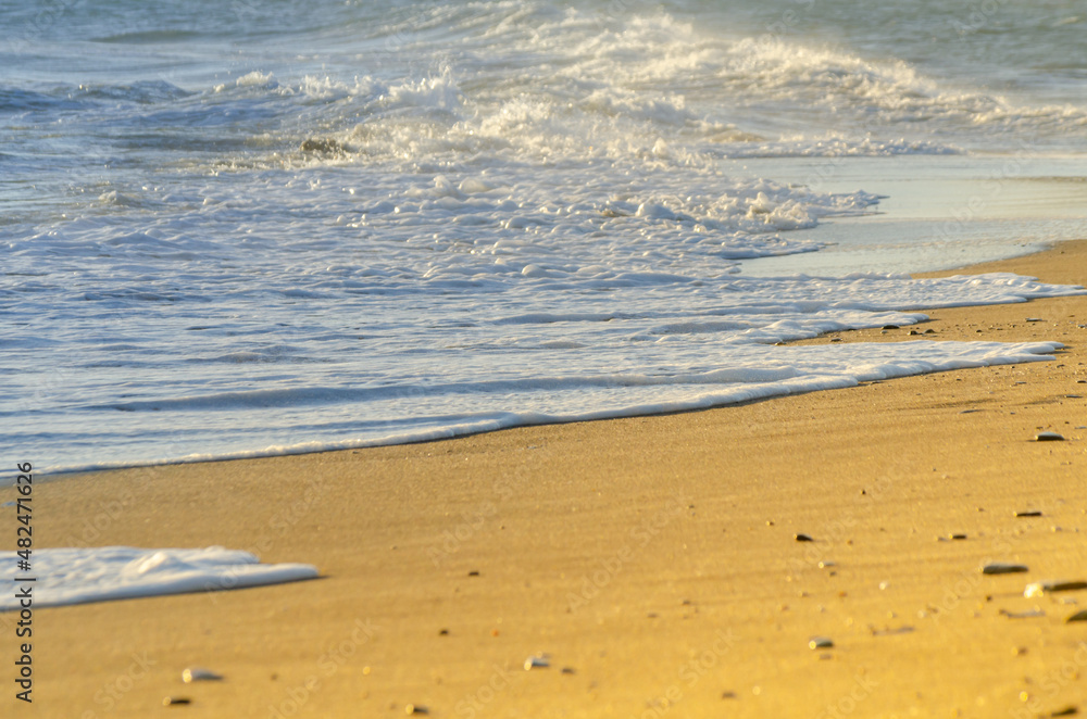 View on the seawater affecting the sand on the beach, sea waves flowing calmly at the sand View on the seawater affecting the sand on the beach, sea waves flowing calmly at the sand