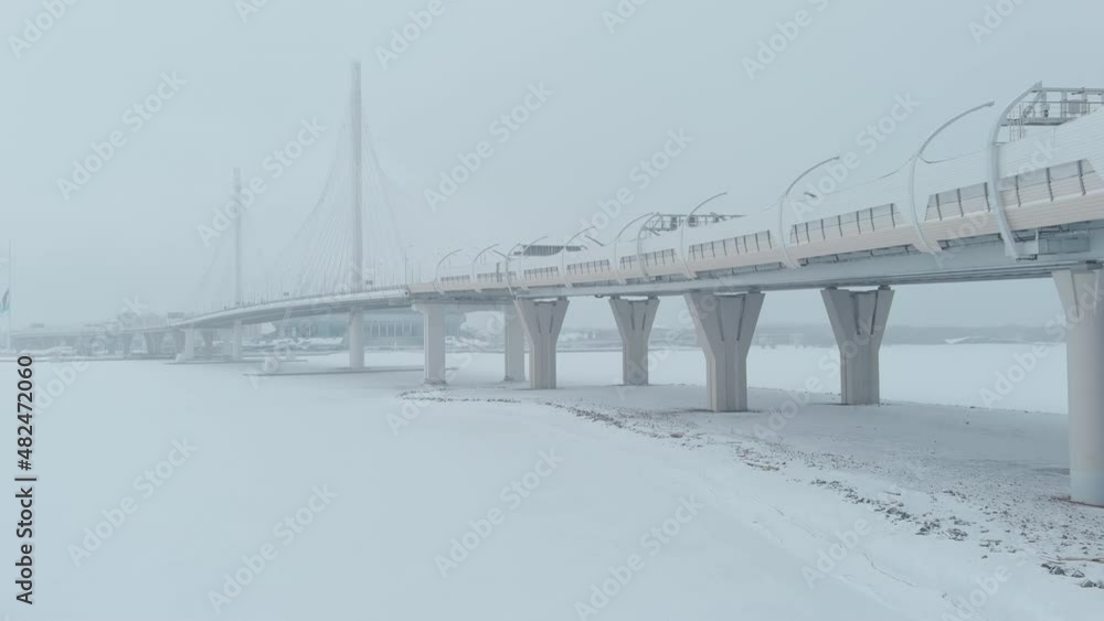 The drone flies along the cable-stayed bridge in a snow storm, highway, blizzard The drone flies along the cable-stayed bridge in a snow storm, highway, blizzard