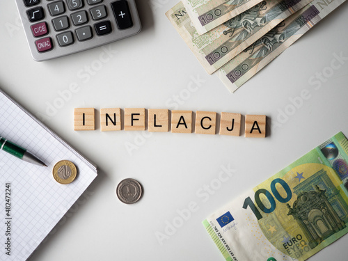 Inflacja - napis z drewnianych kostek, kryzys, wartość, cena złotówki, złoty, euro, ​kalkulator, pieniądze, długopis, flatlay