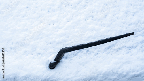 windshield wiper on snow-covered car window