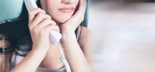 woman talking on a wired home phone