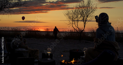 Friends group party beach on sunset sea coastline background. Family on picnic.