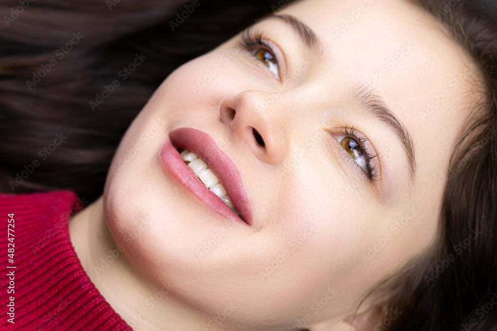 Obraz premium close-up of naked model girls and a ready-made permanent lip makeup procedure for her