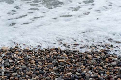 Runde Steine an einem Strand am Meer.