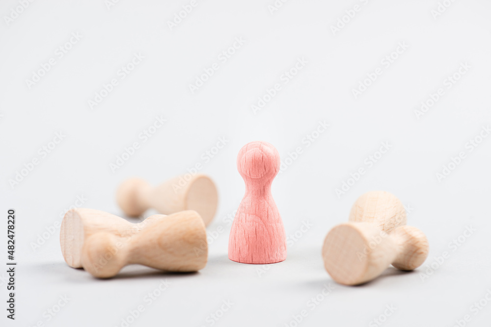 Fototapeta premium Group of wooden figures, one leader is standing, others have fallen, outstanding leadership, successful strategy, business concept, be the winner