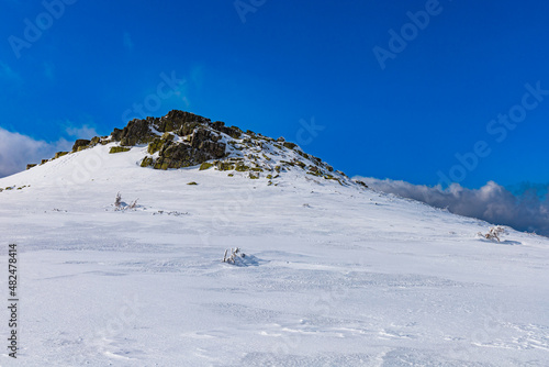 Pile of stones on top of the mountain full of fresh snow in mountains