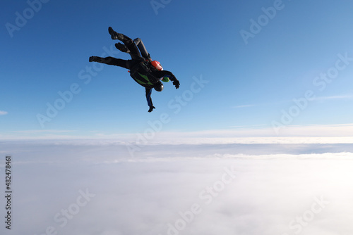 Skydiving. Tandem jump isin the cloudy sky.