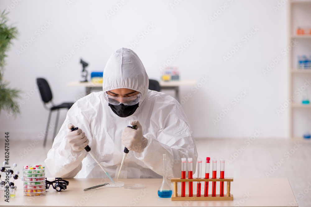 Young male chemist in drugs synthesis concept Young male chemist in drugs synthesis concept