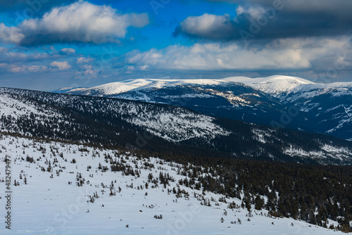 Snowy landscape of mountain trails and hills at cloudy morning