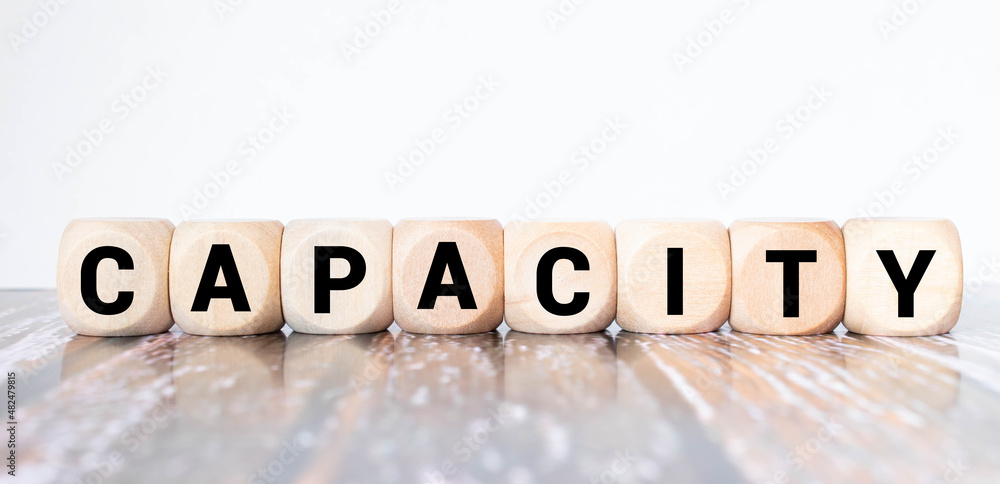 The word CAPACITY is written on a wooden blocks on a yellow background. Business concept. The word CAPACITY is written on a wooden blocks on a yellow background. Business concept.