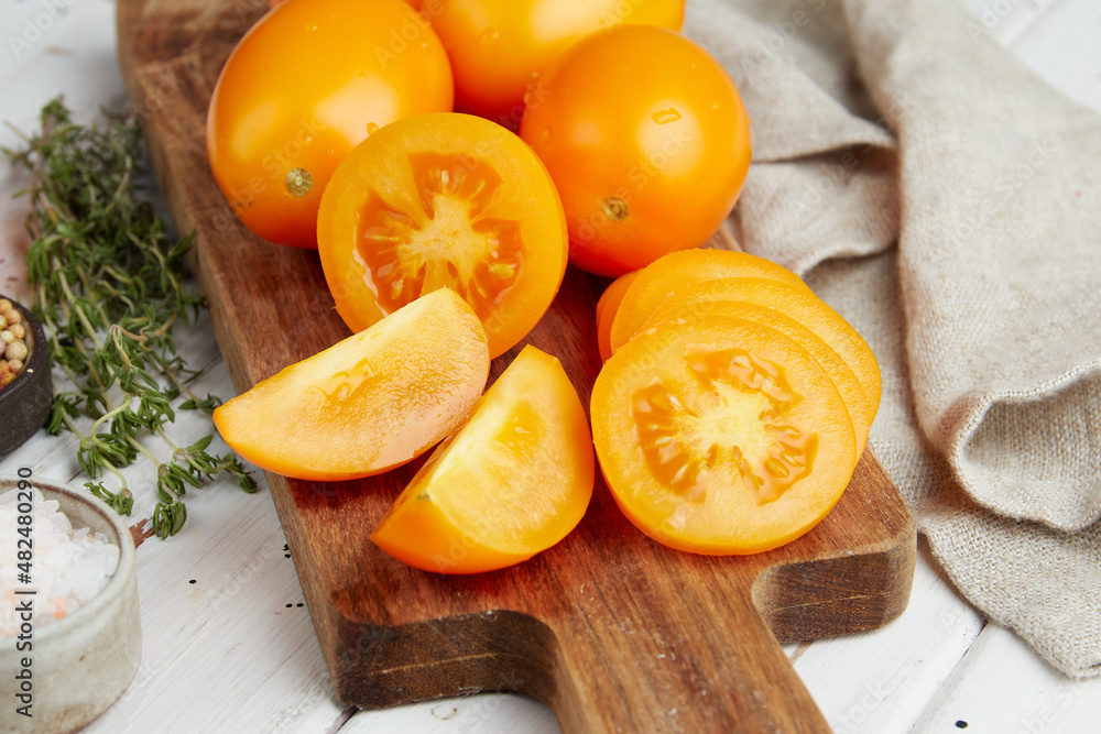 Fresh yellow tomatoes, close-up of fresh, ripe tomatoes on wooden background