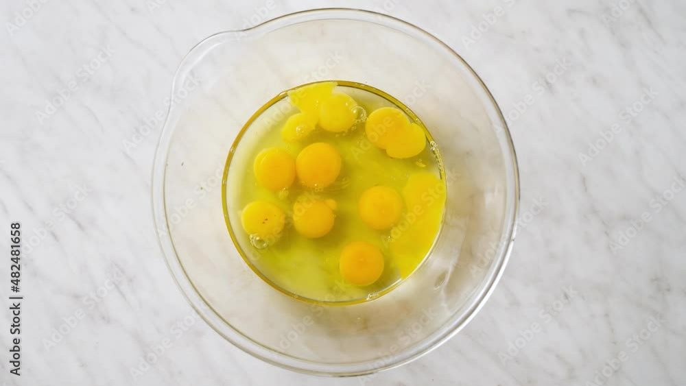 breaking a lot of eggs into a glass bowl breaking a lot of eggs into a glass bowl