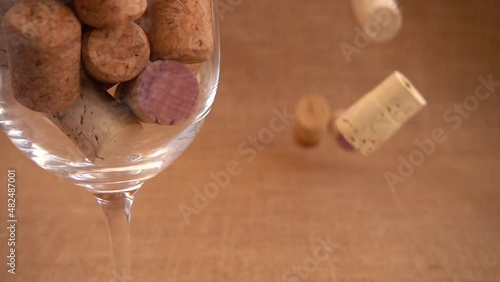 Wine corks fall on burlap against a background of wineglass. photo