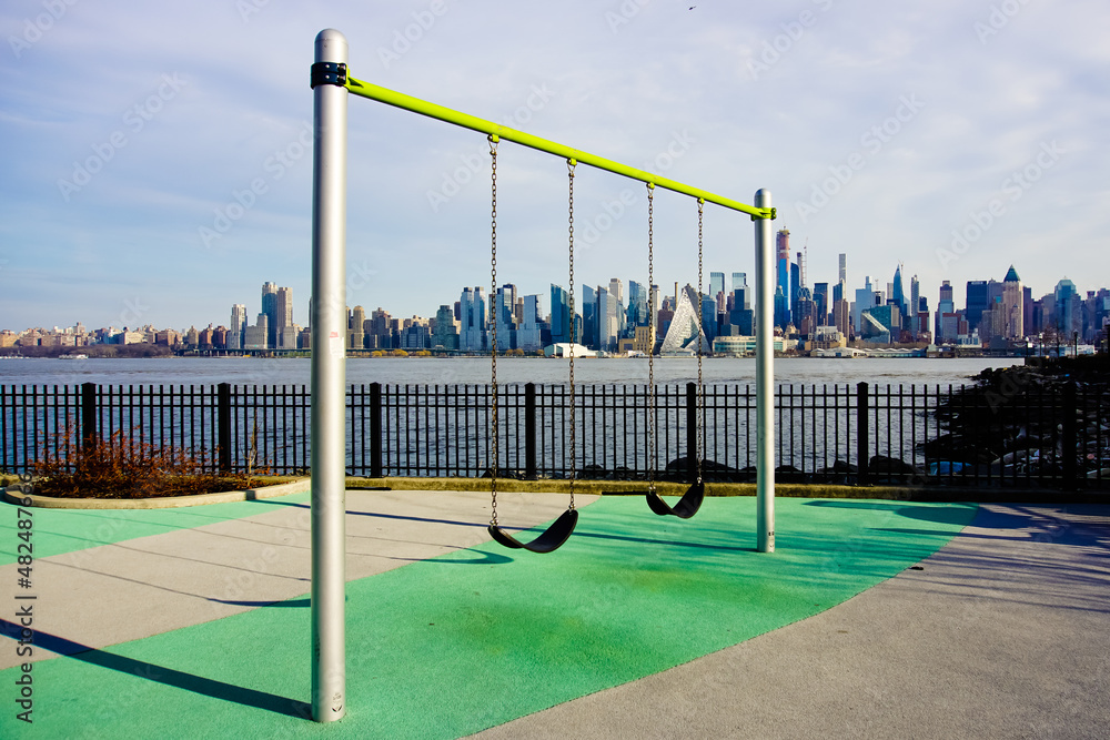 Swing set with the background of Manhattan skyline and Hudson River weehawken NJ USA