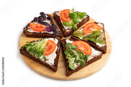 Grain rye bread sandwiches with cream cheese, tomatoes and microgreen isolated on white. side view.