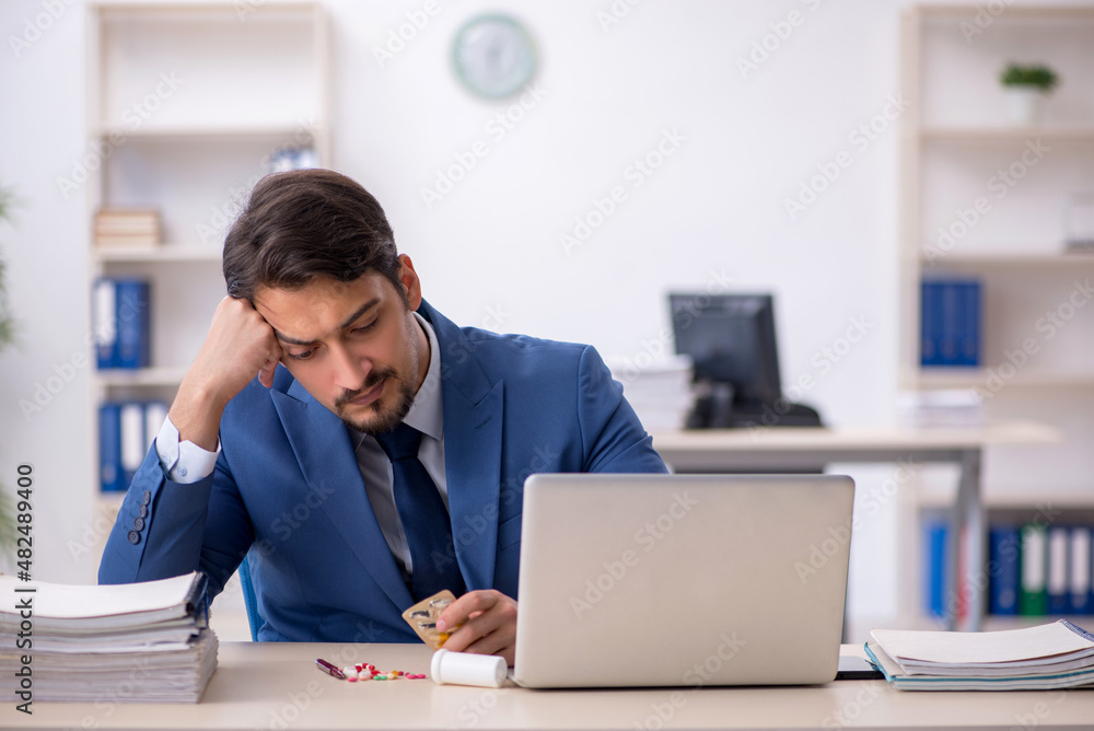 Young male employee suffering at workplace Young male employee suffering at workplace