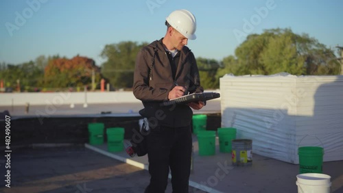Roofing project manager supervising a flat roof build