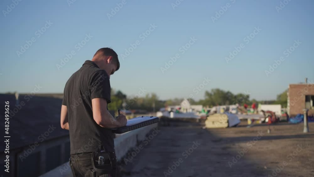 Roofing project manager supervising a flat roof build Roofing project manager supervising a flat roof build