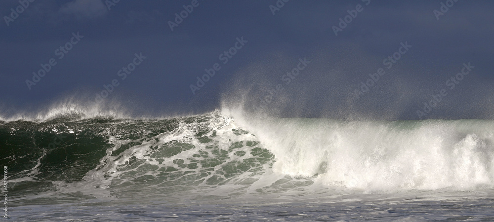 Seascape. Powerful ocean wave on the surface of the ocean. Wave breaks on a shallow bank. Stormy weather, stormy clouds sky background. Seascape. Powerful ocean wave on the surface of the ocean. Wave breaks on a shallow bank. Stormy weather, stormy clouds sky background.