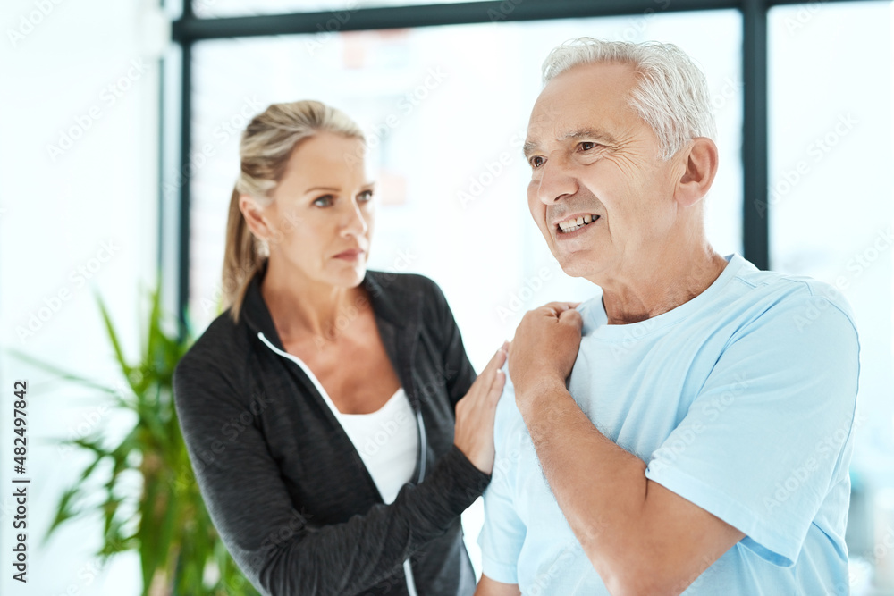 Let's see how serious it is. Shot of a senior man consulting with his physiotherapist in her office.