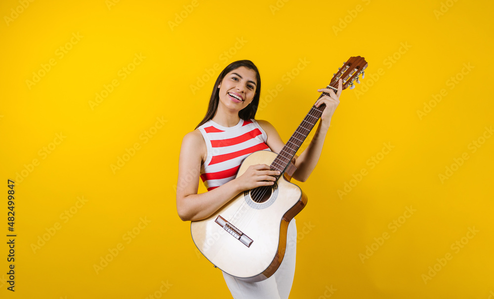 portrait of young latin woman holding a guitar on music concept and copy space on yellow background in Latin America
portrait of young latin woman holding a guitar on music concept and copy space on yellow background in Latin America