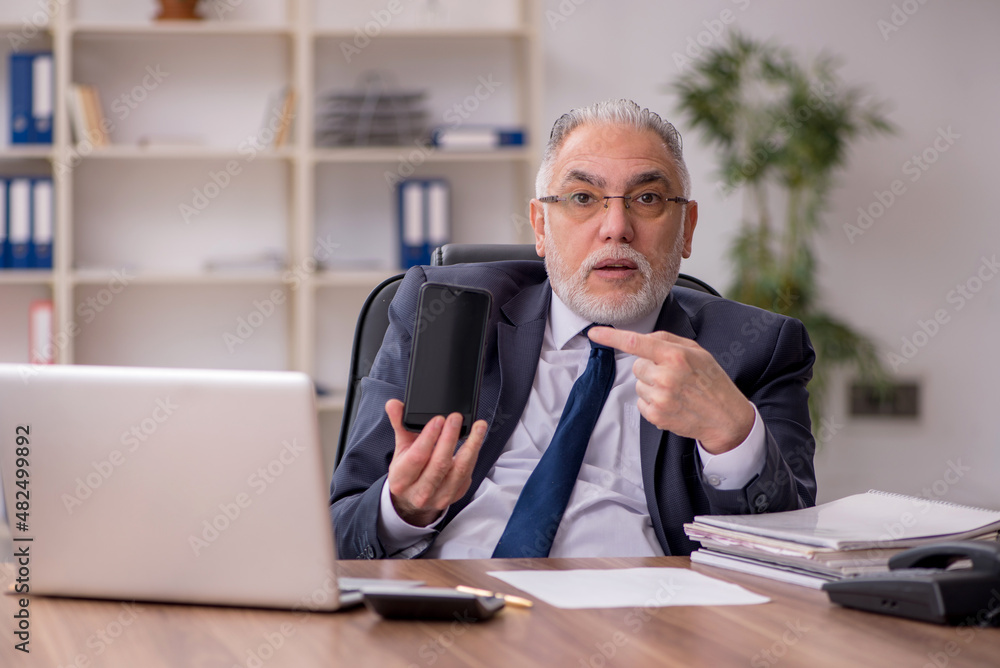 Old male employee working in the office Old male employee working in the office