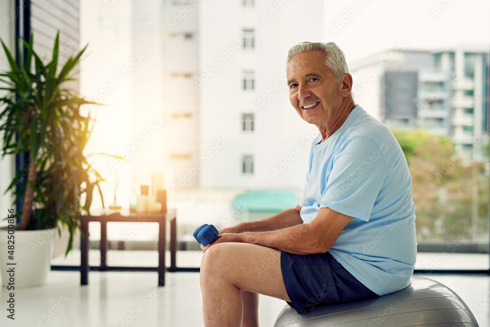 My body, my investment. Portrait of a fit senior smiling while lifting weights at the fitness center. My body, my investment. Portrait of a fit senior smiling while lifting weights at the fitness center.
