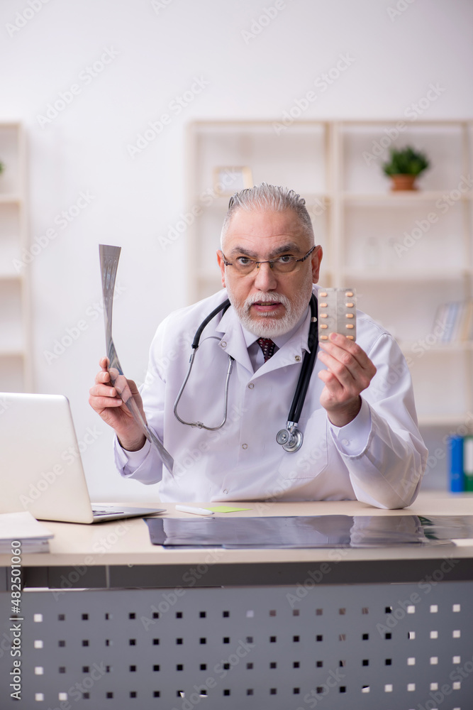 Old male doctor radiologist working in the clinic Old male doctor radiologist working in the clinic
