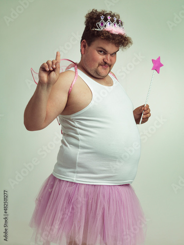 I've got something for you. Shot of an obese man wearing a fairy costume. photo