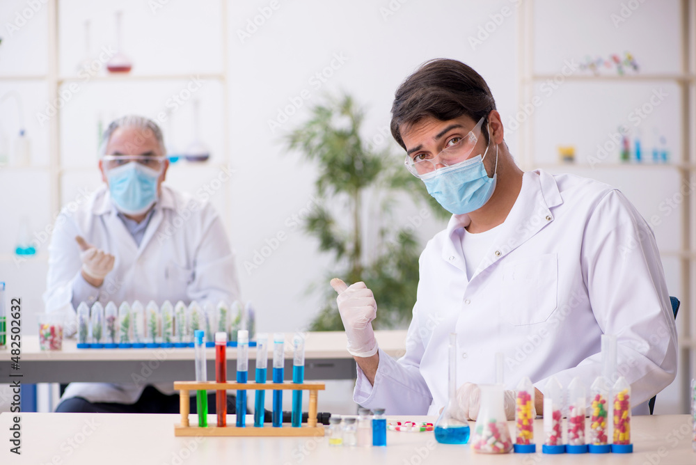Two male chemists in drugs synthesis concept at the lab Two male chemists in drugs synthesis concept at the lab