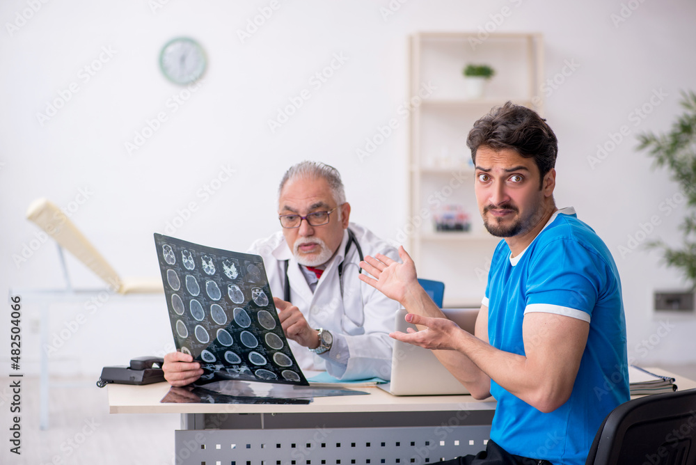 Young male patient visiting old male doctor radiologist Young male patient visiting old male doctor radiologist