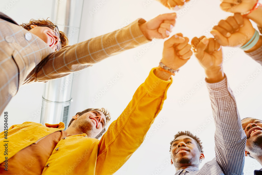 coworkers of different races bumping their fists as a sign of union