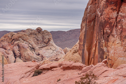 Overton, Nevada, USA - February 24, 2010: Valley of Fire. Detail of red and beige rocks with dry desert on horizon under heavy rainy gray cloudscape.