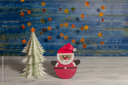 Santa Claus and tree made with recycled paper surrounded by stars made with orange peel. Happy new year and merry Christmas. Holiday card