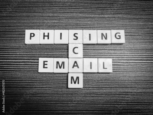 Crossword phising scam email made from square letter tiles against black background. photo