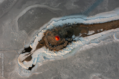 The sea lighthouse on the stone spit Tokarevskaya Koshka, in winter, Vladivostok, Russia. Top view photo