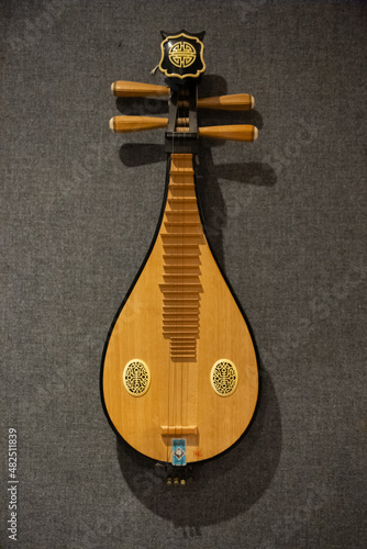 Antique Asian music instrument, pipa, hung in wall in a music studio photo