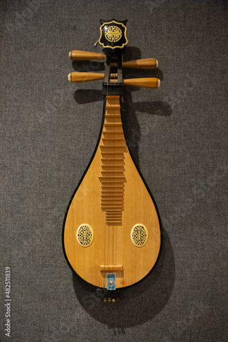 Obraz na plátně Antique Asian music instrument, pipa, hung in wall in a music studio