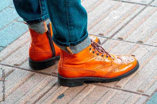 Close-up of pedestrian wearing fashional boots and jeans