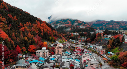 Aerial Drone View of old town next colorful mountain in fall season in Japan photo