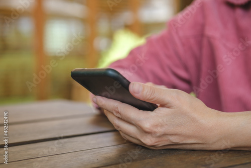 woman shopping online with credit card at coffee shop in outdoor.close up hand holding smartphone