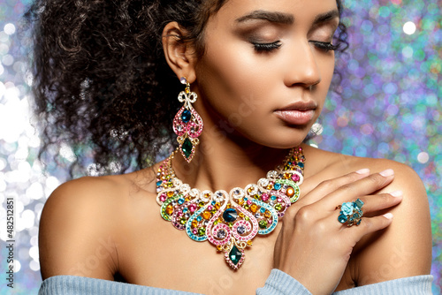 Beauty woman with a set of jewelry and afro hair. Beautiful girl in a necklace with a earrings, ring. Beauty and an expensive accessories, bijouterie.