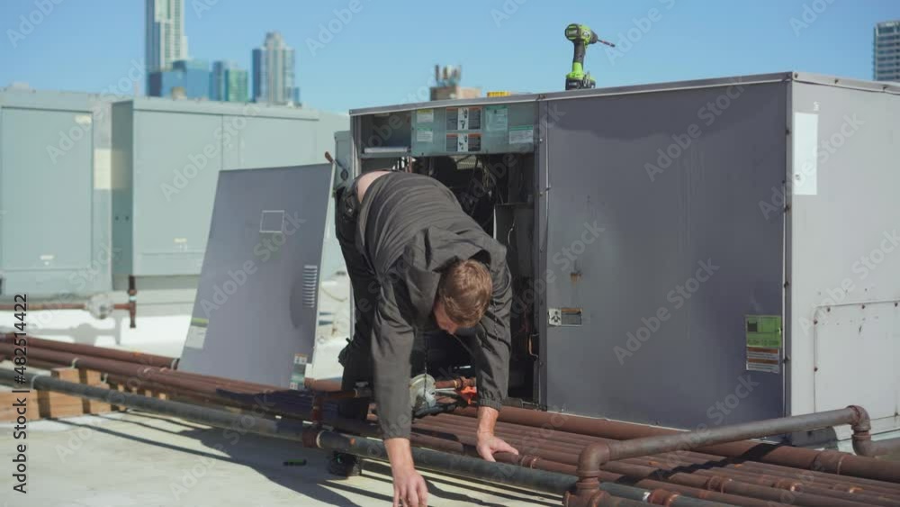 Inspector performing an HVAC unit inspection on a commercial building Inspector performing an HVAC unit inspection on a commercial building