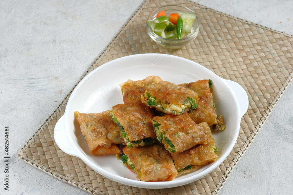 Martabak Telur or omelette murtabak, savory pan-fried pastry stuffed with egg, meat and spices with curry sauce,is an Indonesia traditional street food Martabak Telur or omelette murtabak, savory pan-fried pastry stuffed with egg, meat and spices with curry sauce,is an Indonesia traditional street food
