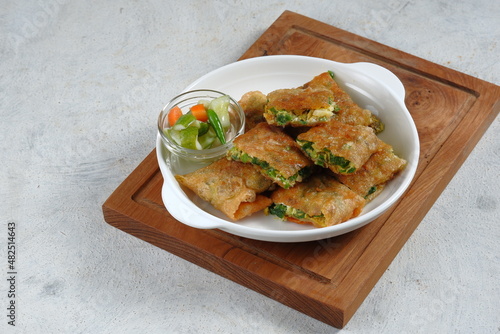 Martabak Telur or omelette murtabak, savory pan-fried pastry stuffed with egg, meat and spices with curry sauce,is an Indonesia traditional street food photo